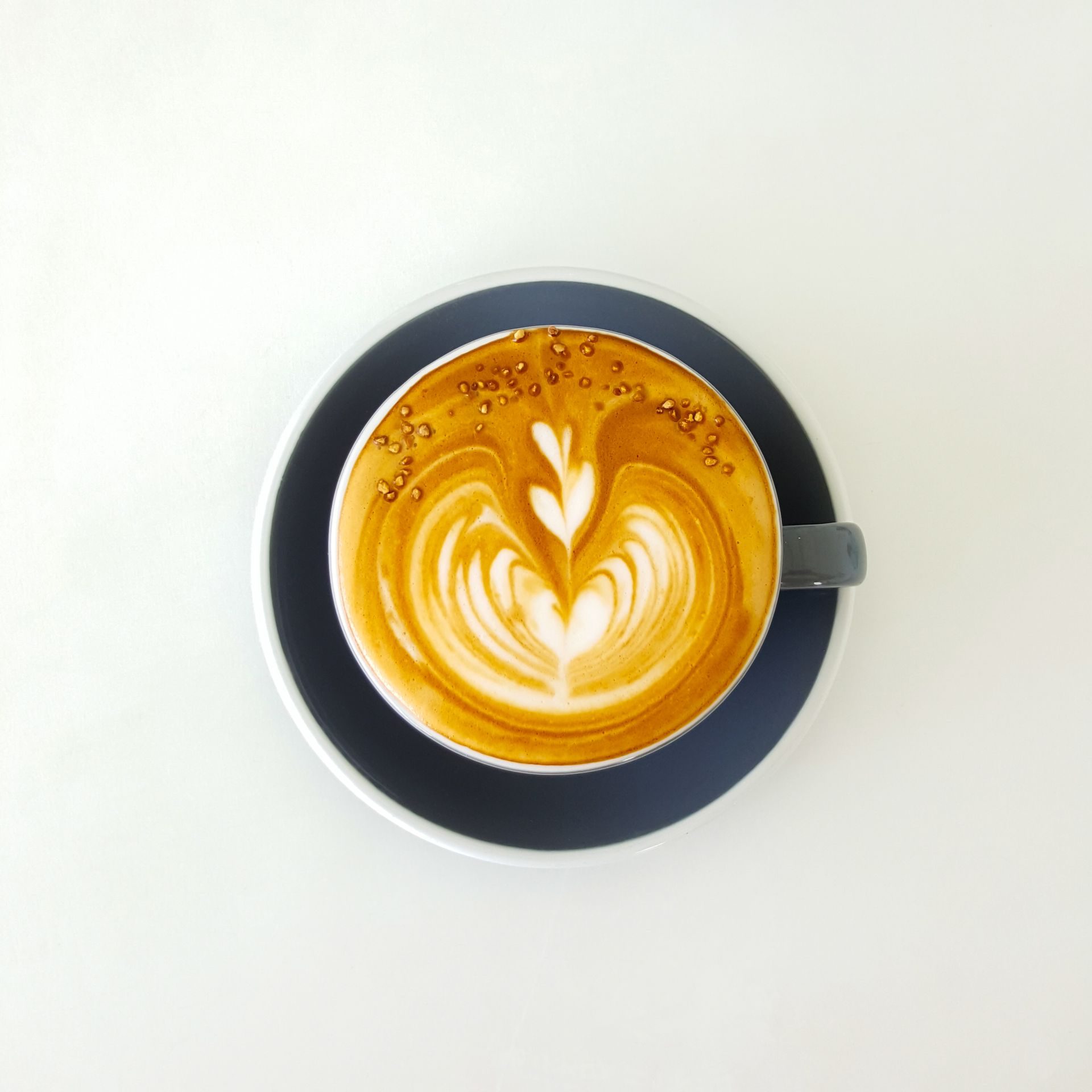 Taza de café con arte latte en forma de corazón vista desde arriba